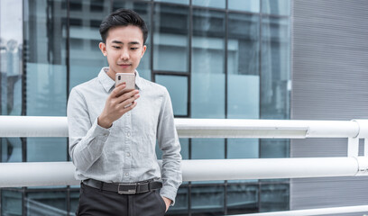 Fototapeta premium Asian business people against the railings is using cell phone