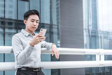 Asian business people against the railings is using cell phone