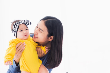 Portrait of beautiful young Asian mother playing and smiling together with his newborn little baby...