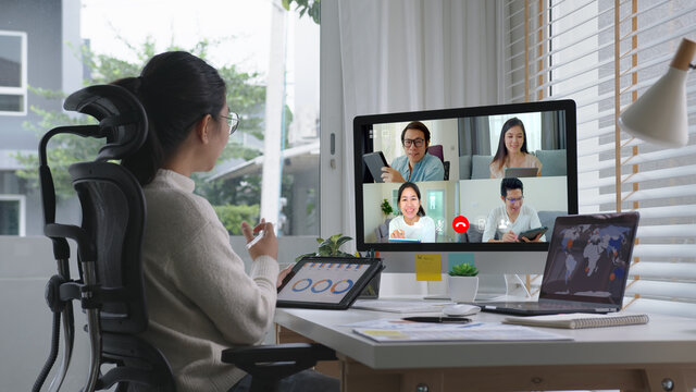 Business woman talking about sale report in video conference.Asian team using laptop and tablet online meeting in video call.Working from home,Working remotely and Self isolation at home