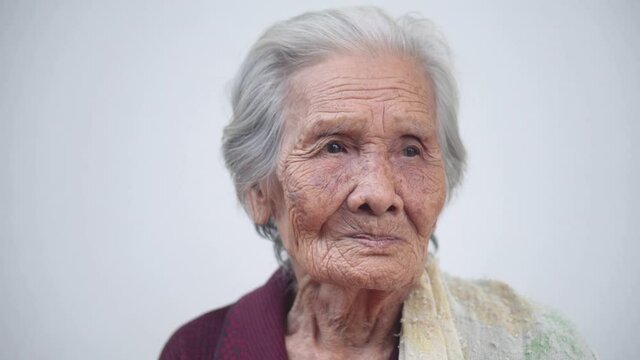 Portrait of Asian senior woman, Head and shoulders view of older woman with short grey hair, Elderly woman with white background