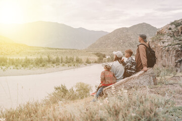 family sitting on the rock