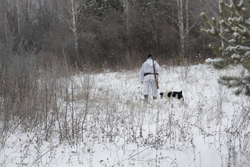 hunter with a gun and a dog in search of a trophy