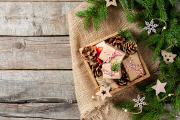 Christmas gift boxes in ecofriendly craft paper. Gifts in a wooden box on a wooden table. Eco-friendly gift packaging	