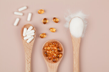 Supplements for health , vitamin D zinc and vitamin C powder in wooden spoons on beige background.