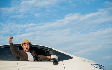 Fototapeta na wymiar Young handsome asian man wearing hat driving car go to travel on a bright day beautiful blue sky.