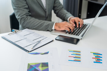 Close up businessman hands using laptop while work in office. Focusing Finger texting keyboard of laptop computer.