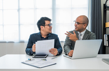Two businessmen are discussing various business topics. A team of business people chatting in an office meeting room.