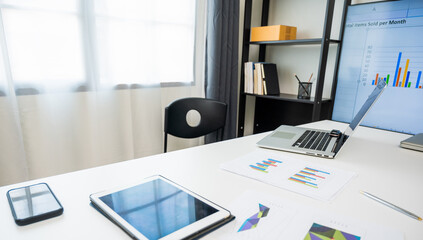A business man's desk has a laptop And a lot of paper work