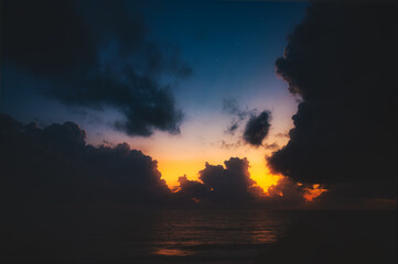 Beautiful sunset over sea with reflection in water, majestic clouds in the sky