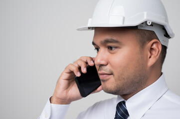 Asian engineer talking with customer on phone to home service. Worker wearing hard hat using smartphone standing on isolated white background.