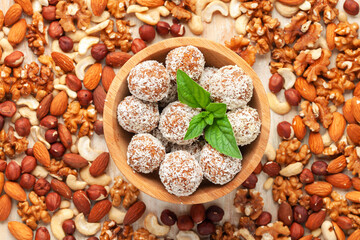 Sweet protein vegan balls in a bowl and various nuts. Homemade sugar free candy. Top view