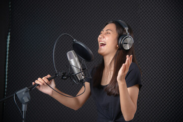 Asian lady show her talent by singing in music studio record room