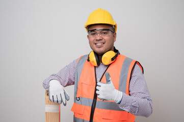 Young asian craftsman with wood standing and showing thumbs up in studio white background. Carpenter in uniform go to working.
