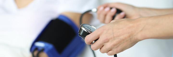 Doctor measures pressure with a tonometer to patient.