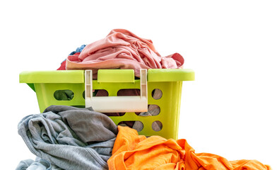 Isolated used cloth in green plastic basket on white background, front view of green basket, clothes full in basket and some is outside. Bright color clothes.