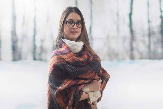 Portrait of a woman in spectacles wrapped in a shawl 	