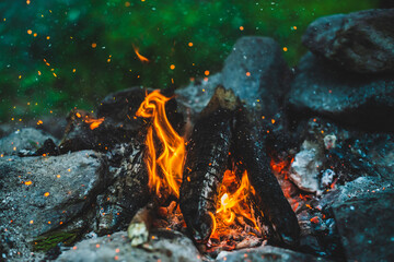 Vivid smoldered firewoods burned in fire closeup. Atmospheric background with orange flame of...