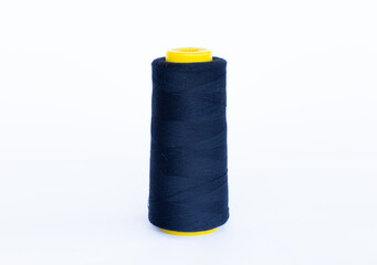 Dark blue bobbin thread isolated in white background. close up thread-like yarn for sewing.