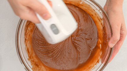 Mixing chocolate batter using an electric mixer. Chocolate muffins or chocolate cupcakes recipe