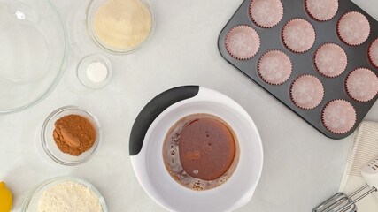 Chocolate muffins recipe. Mixing together cup of coffee, cooking oil and vanilla