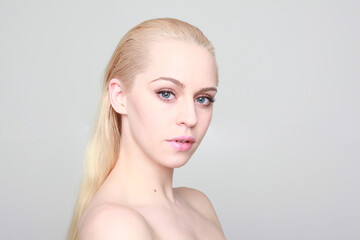 close up portrait of blonde woman with clean skin and blue eyes.  great studio background.