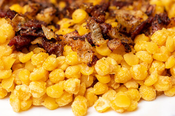 Close up of pea porridge with onions and bacon in the white plate.