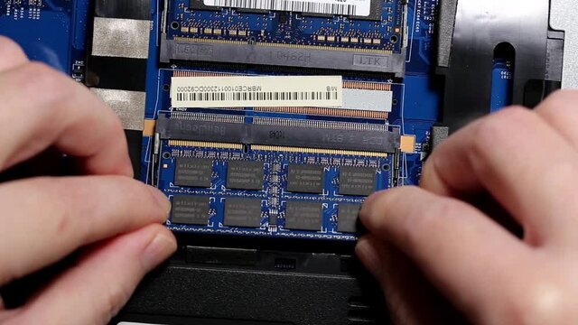 Close up man installing a ram into the laptop