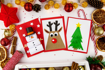 DIY Christmas cards kids. Three cards with a Christmas tree, a deer, a snowman from colored paper.