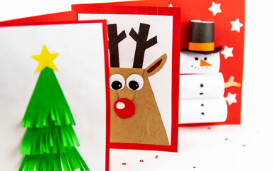 DIY Christmas cards kids. Three cards with a Christmas tree, a deer, a snowman from colored paper.