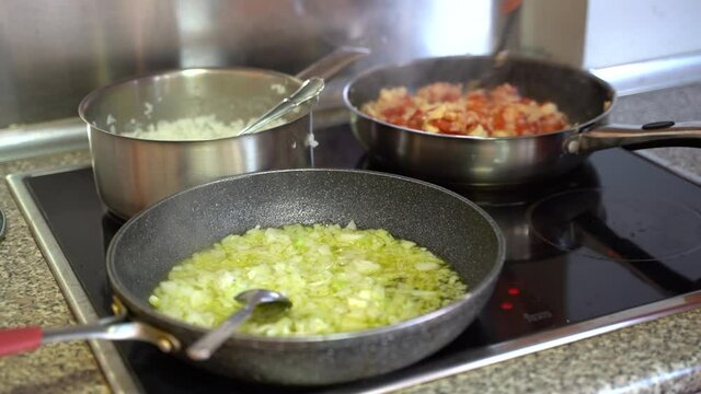 Cooking Djuvec In A Pan While White Onions Being Sauteed On The Other Pan - close up