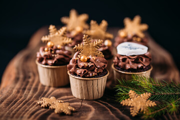 Chocolate cupcakes with star shaped cookies on a wooden background. Christmas mood. Sweets for any occasion