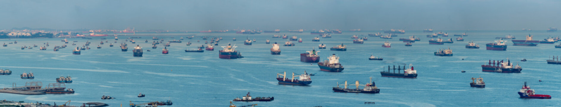 Wide panorama image of Container Ships and tankers anchored at the Singapore strait.