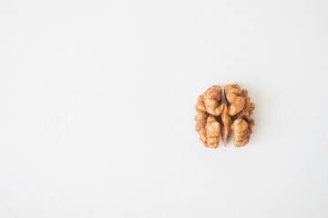 Half of a walnut looks like a brain on a white background.