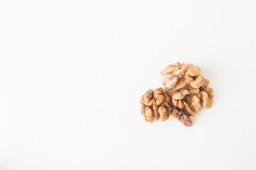 Walnuts peeled and shelled on a white background.
