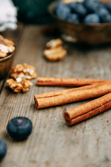 Cinnamon sticks and walnuts on a wooden table close-up.
