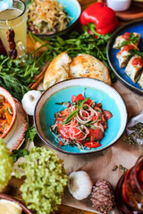Muslim Ramadan iftar family dinner. Flat-lay of people feasting over table with Middle East food. Dates, dolma, kebab, flatbread, pide, borek, sweet, salad, top view. Ramazan fasting Turkish cuisine.