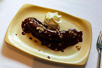 Delicate tropic dessert of fried plantain served with melted dark chocolate and whipped cream © JackF