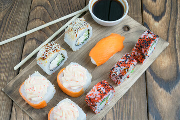 sushi, rolls on a board with chopsticks