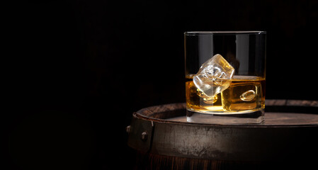 Scotch whiskey glass and old barrel