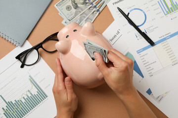 Concept of financial planning with woman puts money in piggy bank