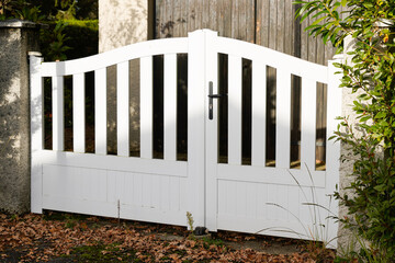 suburban steel metal gate white fence of home suburb street access house garden