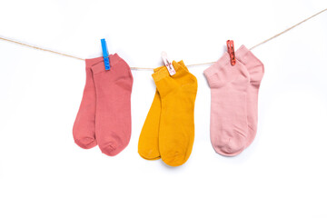colored socks hanging on a rope with clothespins isolated on white background