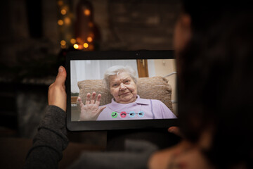 Senior adult is talking via video conference with a younger woman