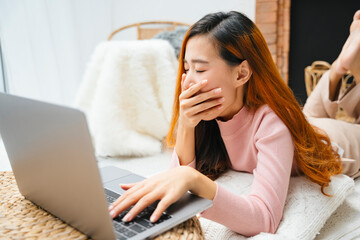 Beautiful asian woman yawning after working on laptop computerใ