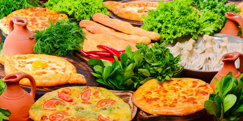 Top view of traditional Georgian cuisine: Kolkh and Adjara khachapuri, khinkali dumplings, shotis puri, kubdari or kubed