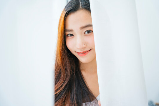 Close Up Portrait Of Beautiful Asian Woman Behind White Curtain.