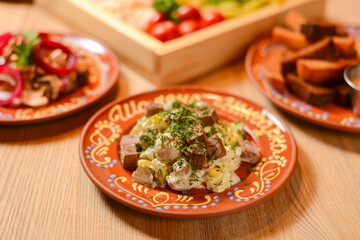 Vegetable salad with mayonnaise. Delicious mayonnaise salad on a plate. Over rustic wooden background.
