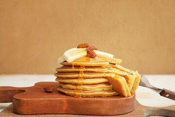 Boards with tasty banana pancakes on table