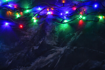 Fototapeta na wymiar Glowing Christmas lights on dark background